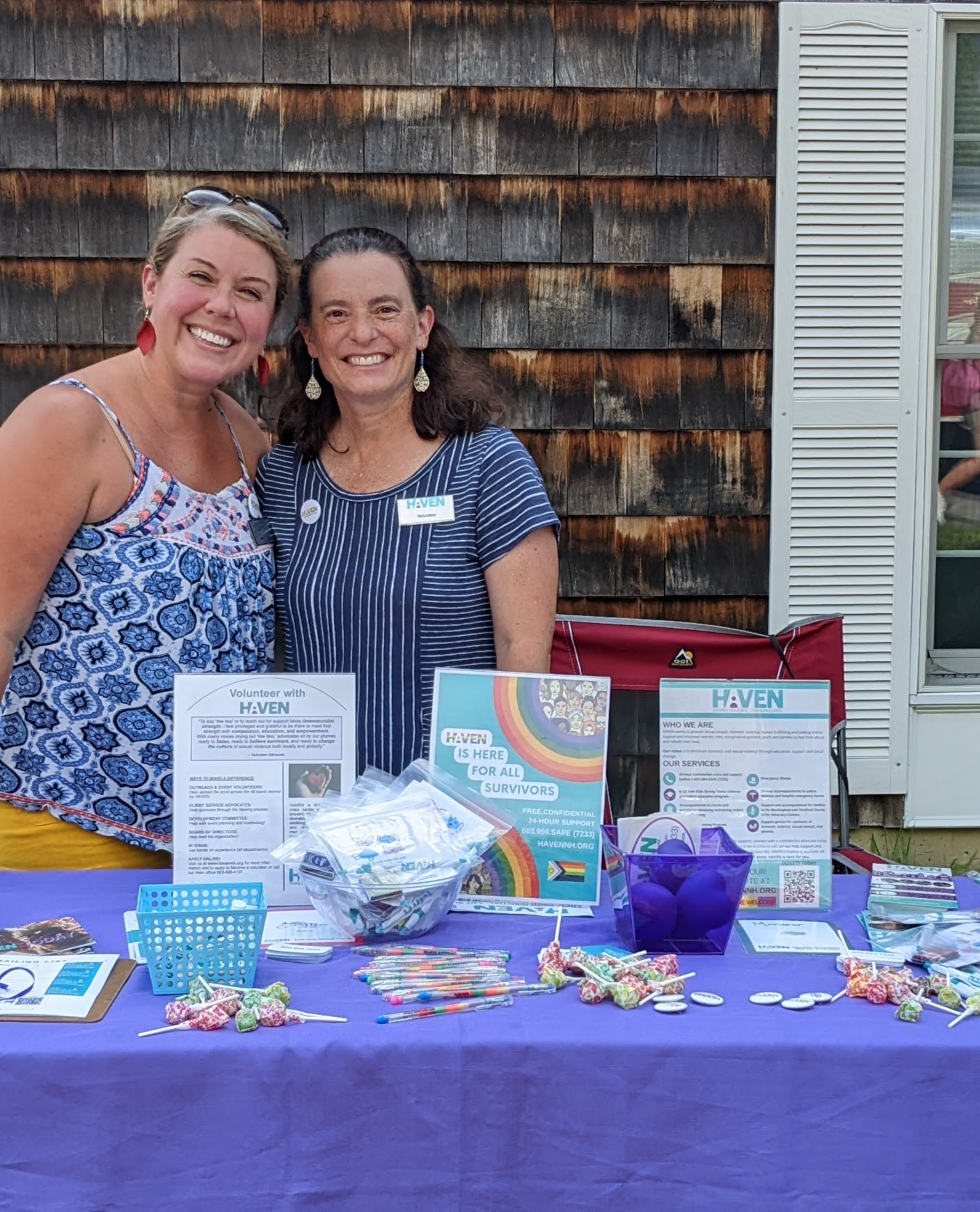 Image description: Two women smiling behind a HAVEN table showing HAVEN swag like pens, information about HAVEN, and candy.